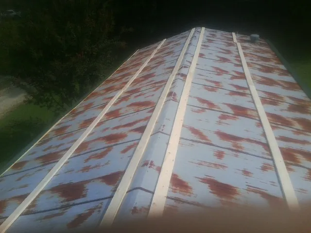 Rusted metal roof panels with new wood purlins before replacement — Storm Damage Roof Repair in Portland by Roofing Brothers