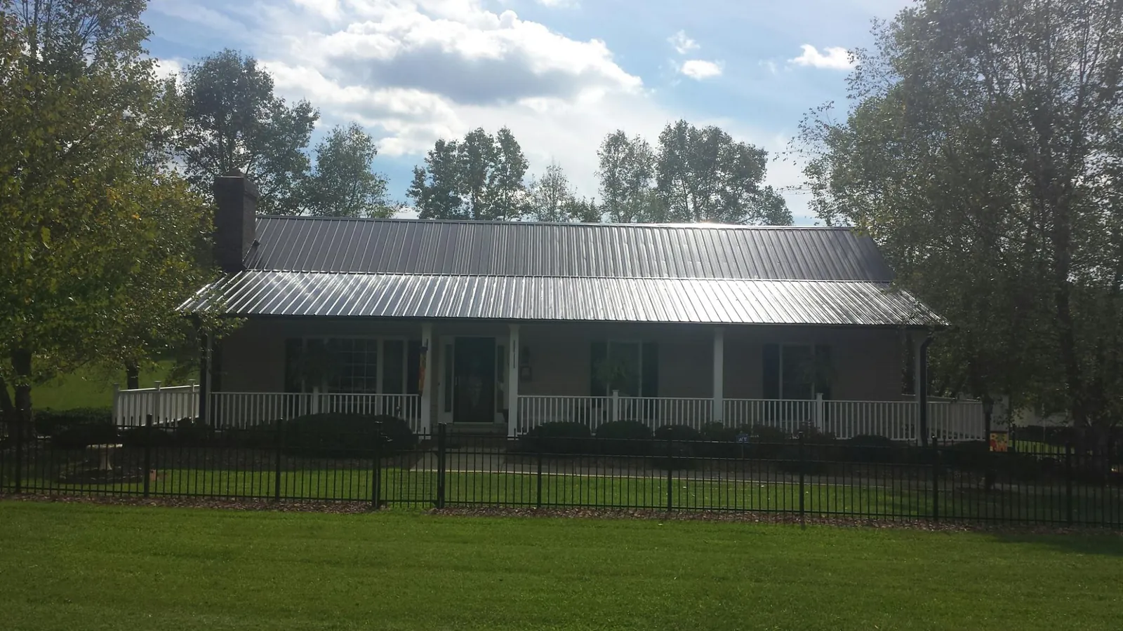 Gray metal roof on a brick ranch with a full width front porch — Gutter Guard Installation work by our crew in Portland